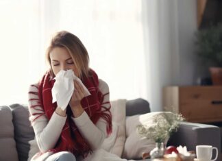 Djevojka sjedi na kaucu i ispuhuje nos