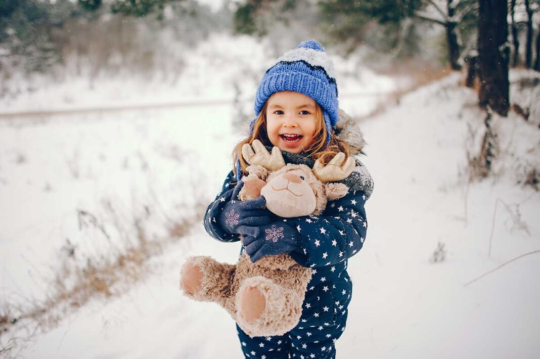 little-girl-blue-hat-playing-winter-forest djevojcica na snijegu