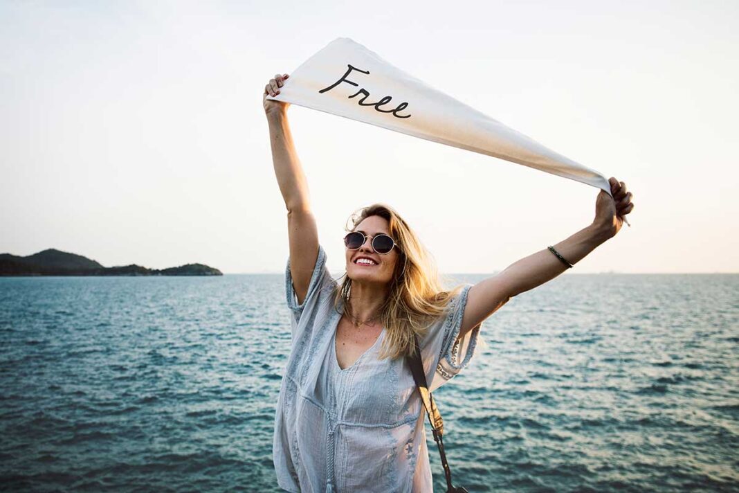 analiziranje djevojka s natpisom free stoji pored mora