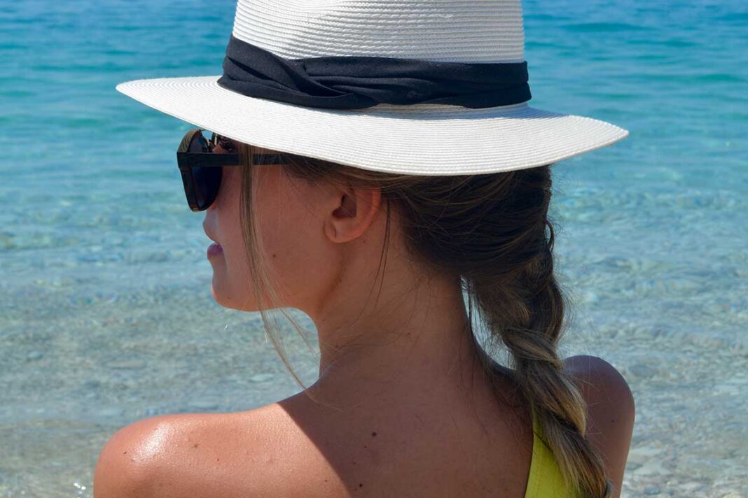 djevojka sa šeširom i naočalama na plaži