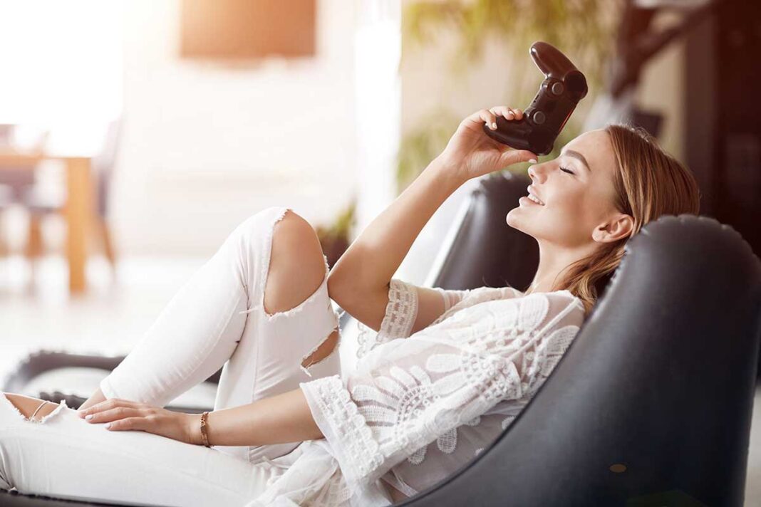 woman zena na kaucu s playstation kontrolerom