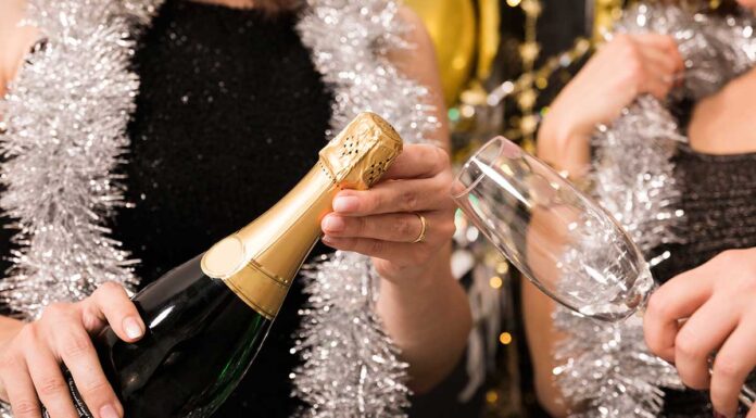8 ideja za kućni party za novogodišnji doček koji izgleda kao da ste ga planirali tjednima Dvije djevojke otvaraju šampanjac - Nova Godina