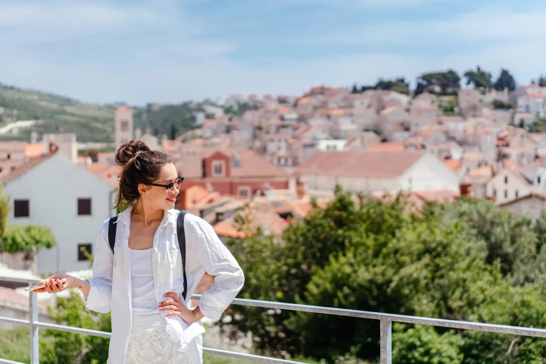 young-beautiful-woman-balcony-overlooking-small-town-croatia (1) djevojka hvar