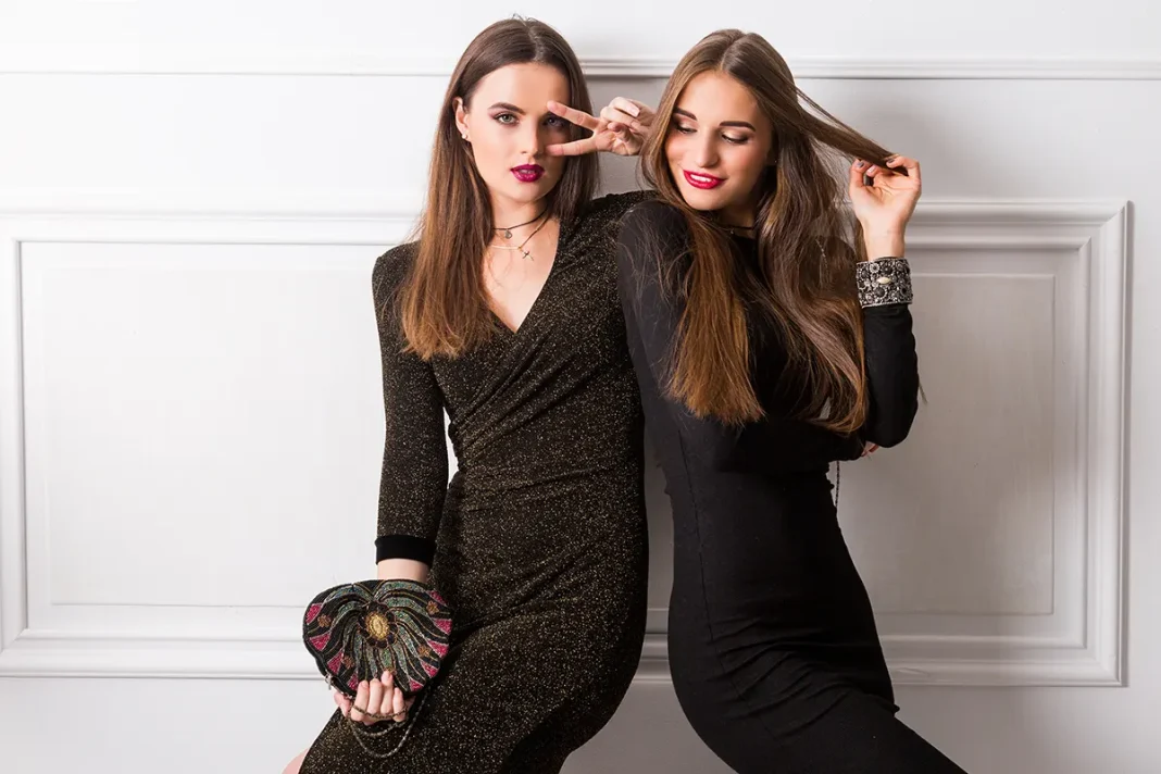 portrait-two-elegant-young-women-glamour-long-dresses-posing-white-wall dvije elegantne mlade zene poziraju